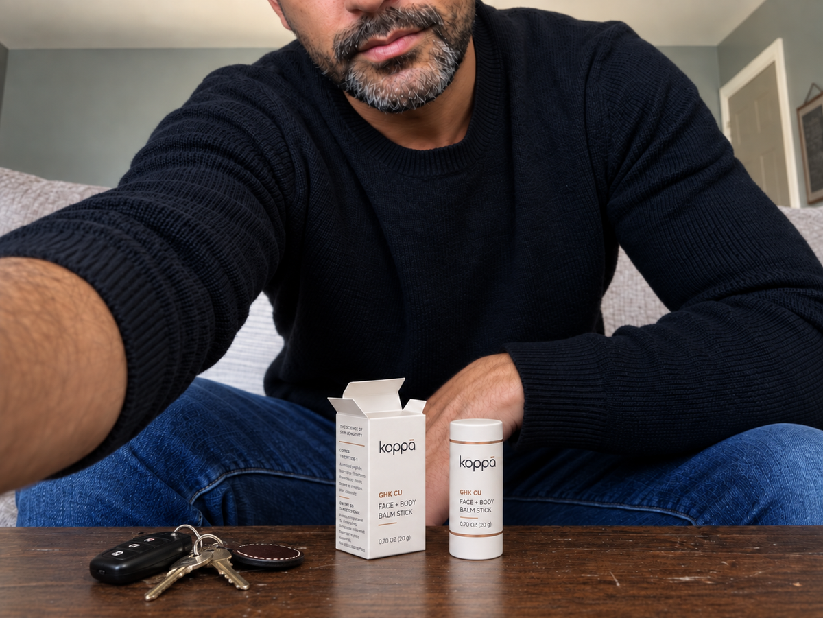 Man with Koppā balm stick and its box on a table