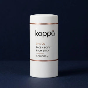 Koppā GHK-Cu Face + Body Balm Stick, a 20 g copper peptide balm in a twist-up stick, on a dark navy background