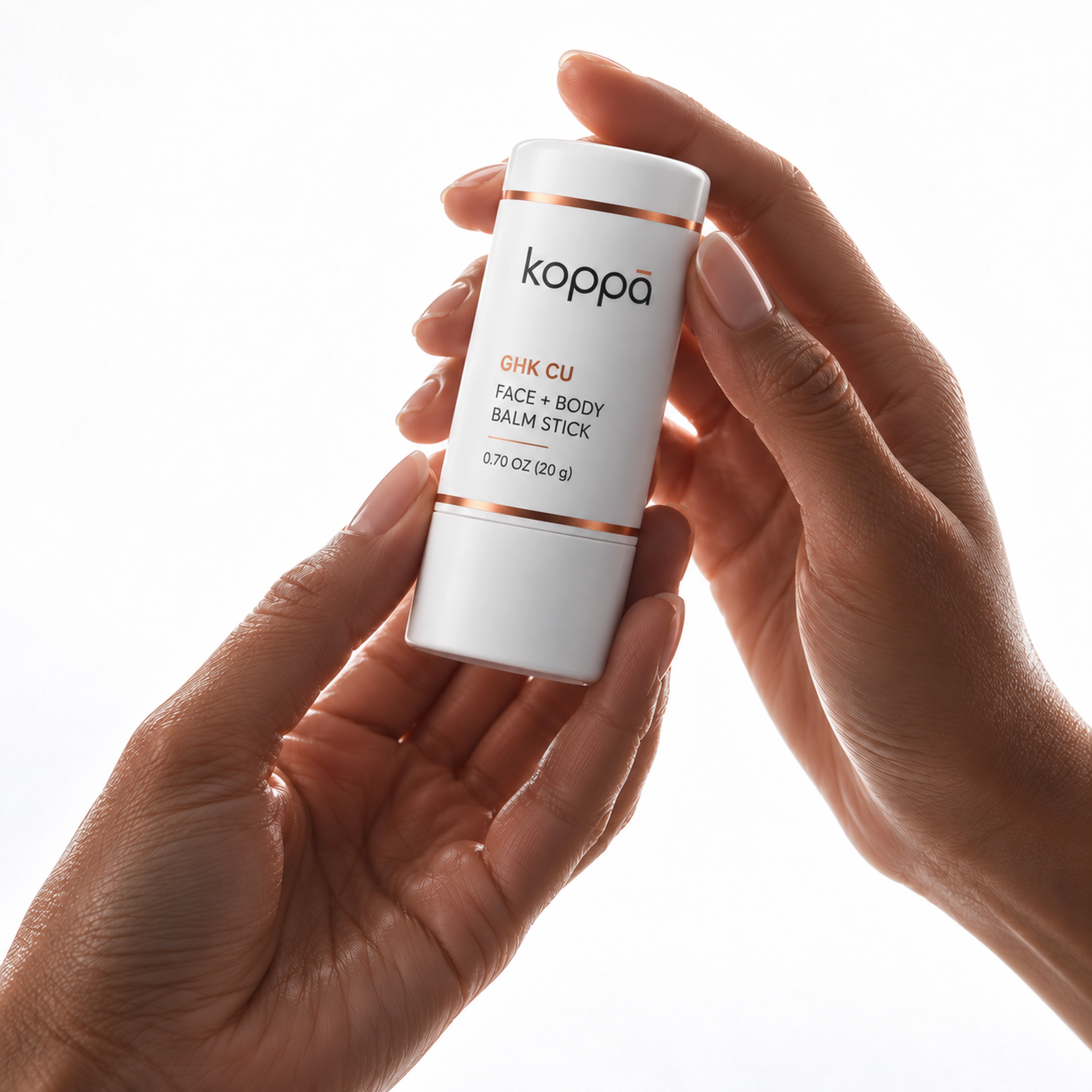 Koppā white and copper balm stick held in softly lit hands