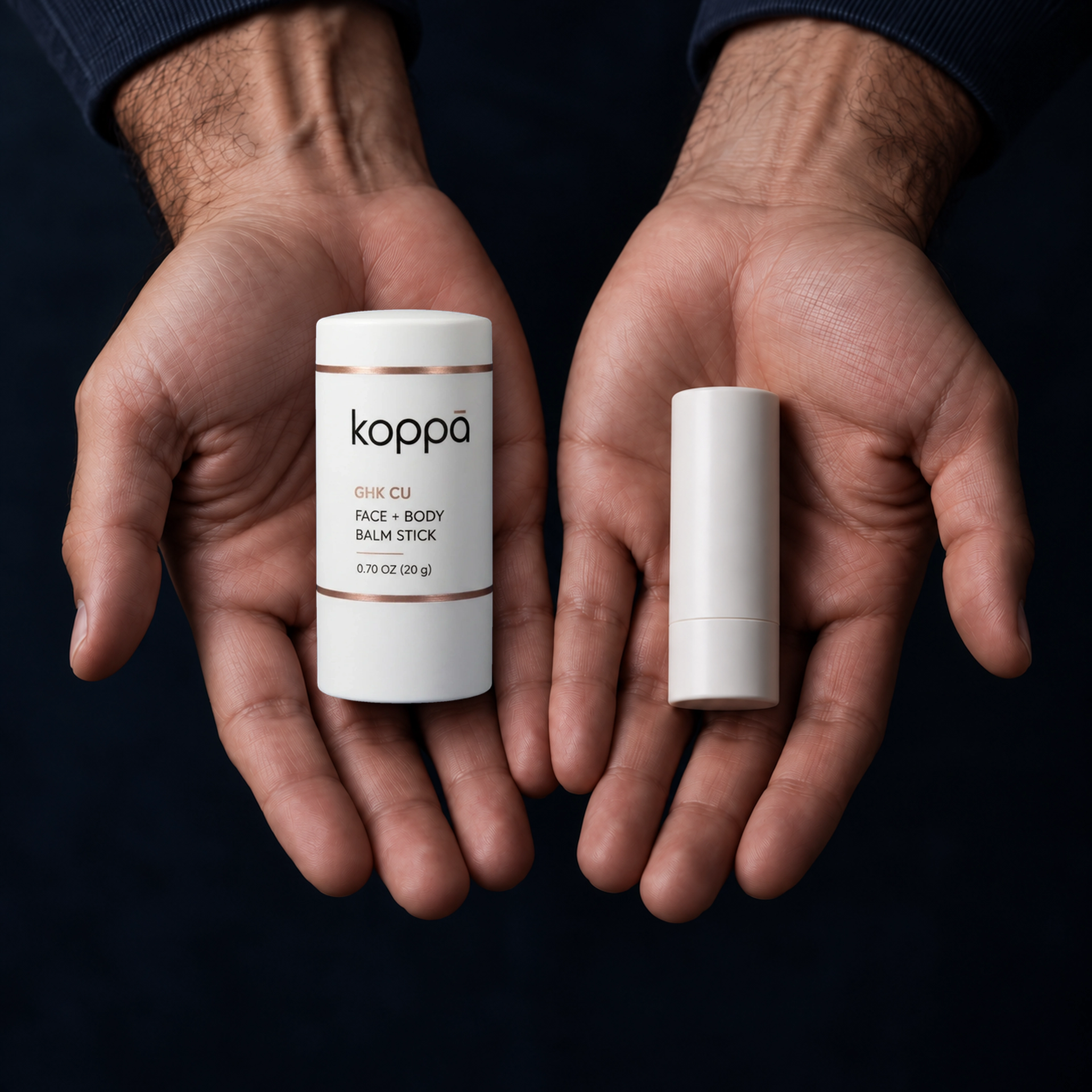 Koppā 20 g balm stick beside a smaller reference stick, held in two hands