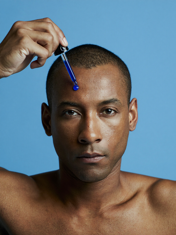 Man applying koppā GHK-Cu blue copper peptide serum with a dropper