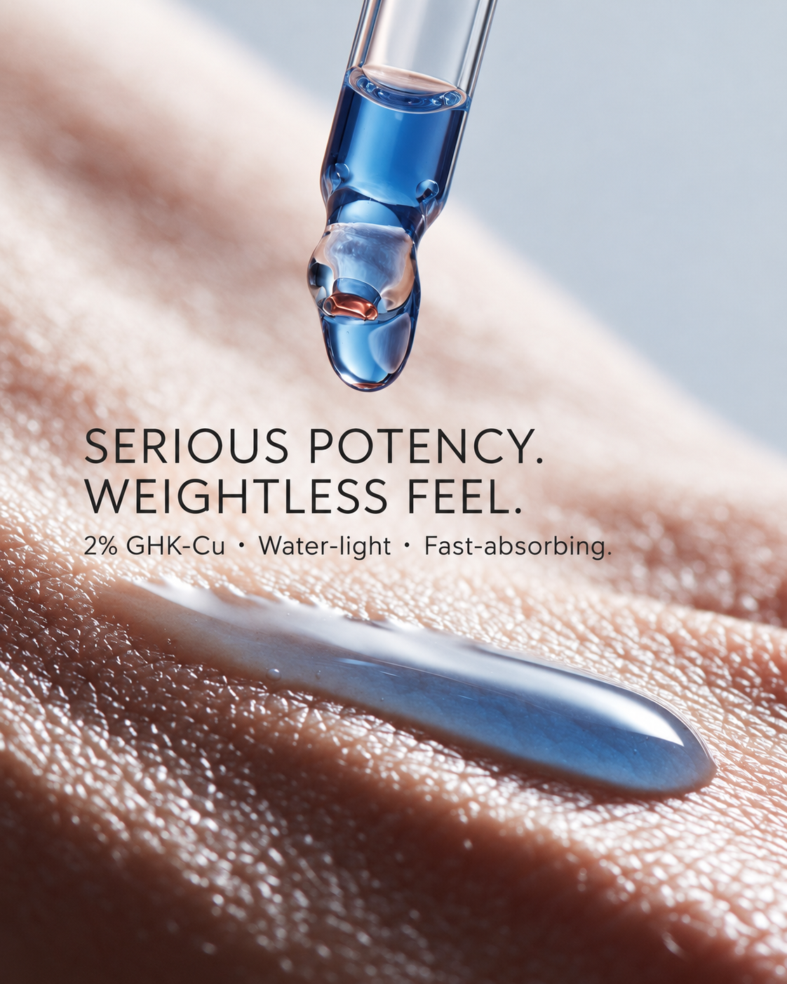 Blue 2% GHK-Cu serum dropping from the glass pipette onto skin, with a water-light swatch below