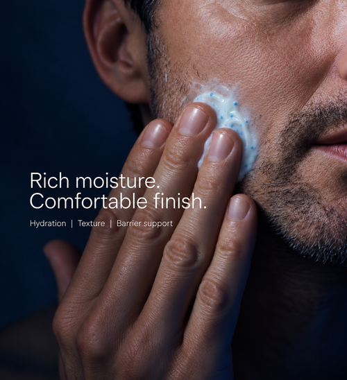 Man massaging copper peptide cream into his cheek with blue capsules visible