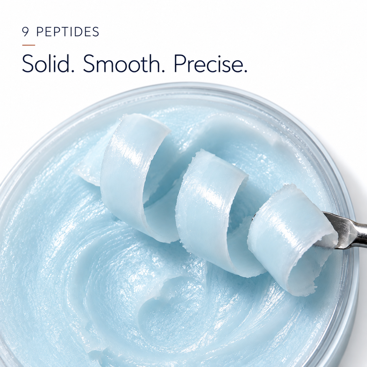 Pale blue GHK-Cu balm curled onto a spatula above the jar, showing the solid 9-peptide texture of the copper peptide stick