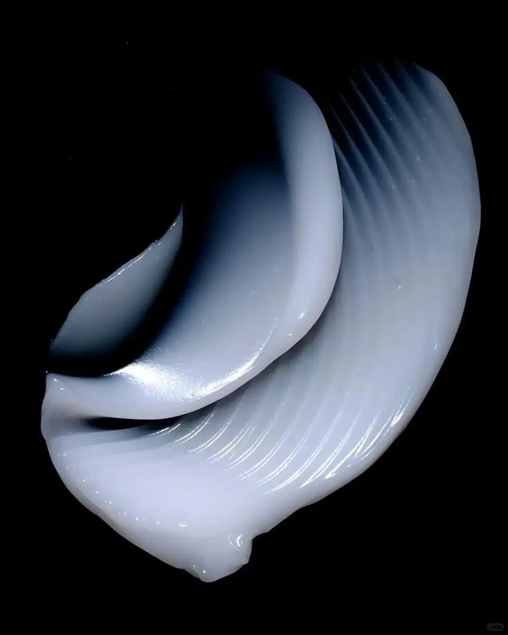 Sculptural pale blue skincare cream texture on a dark background