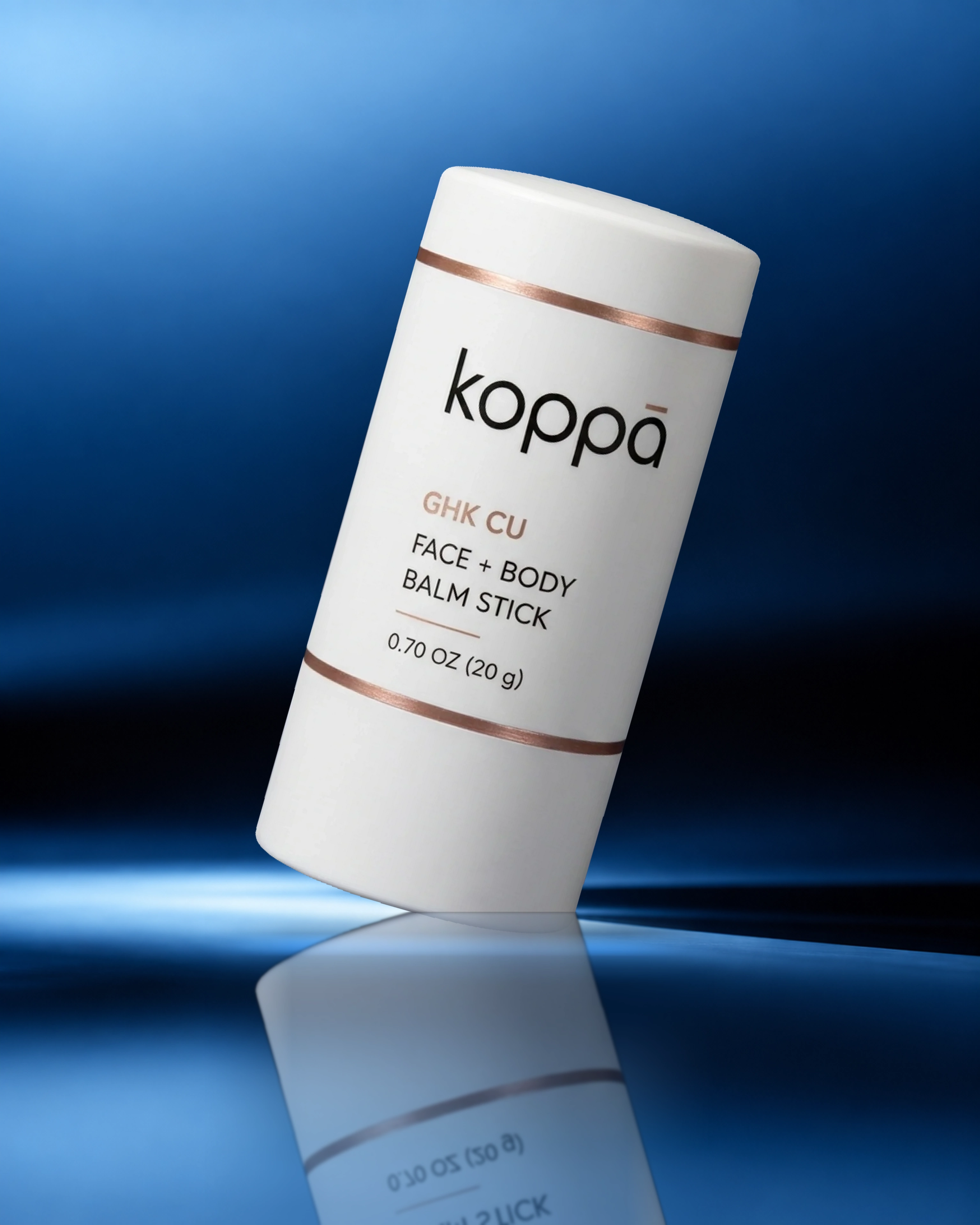 Koppā GHK-Cu Face + Body Balm Stick on a blue studio background