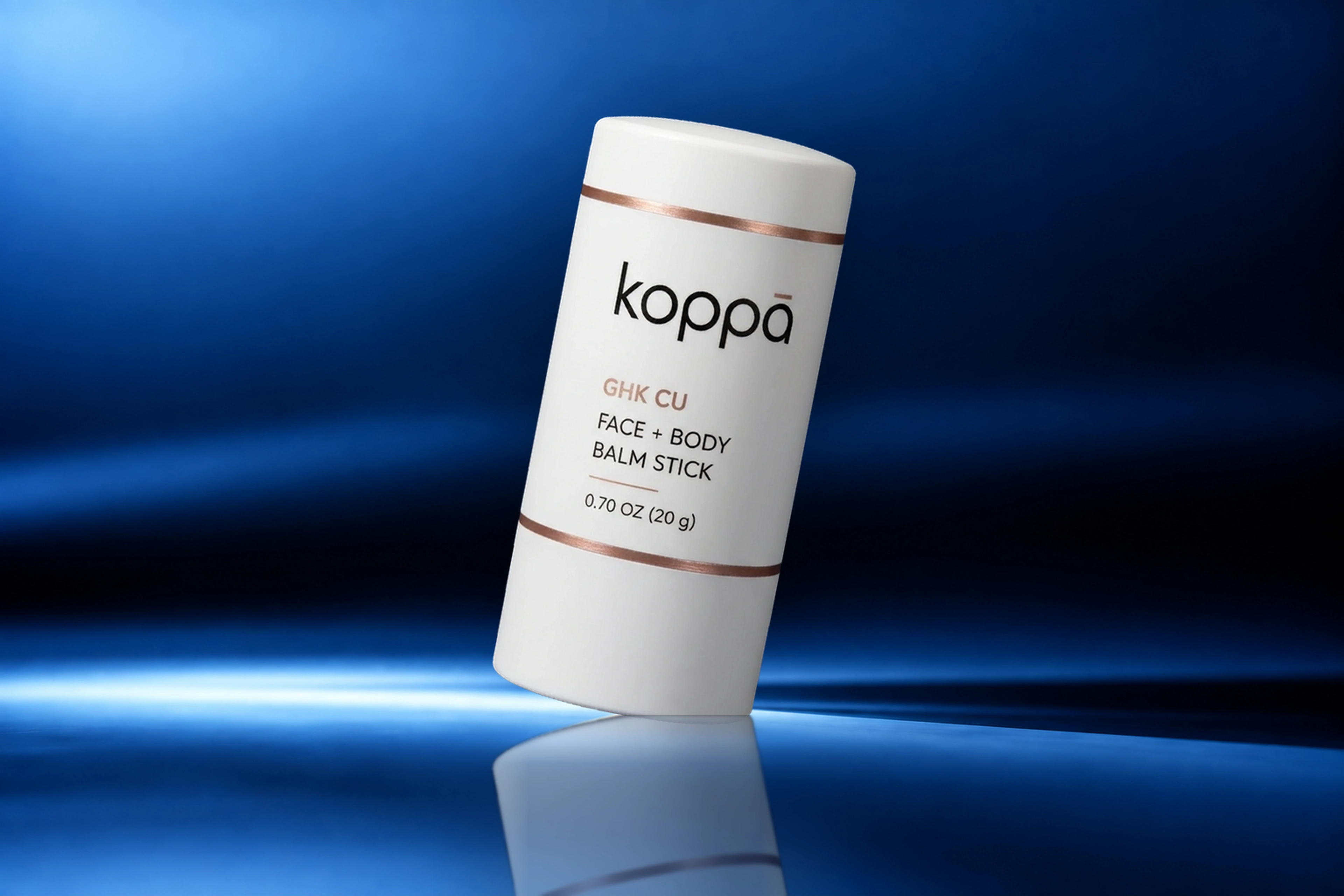 Koppā GHK-Cu Face + Body Balm Stick on a blue studio background