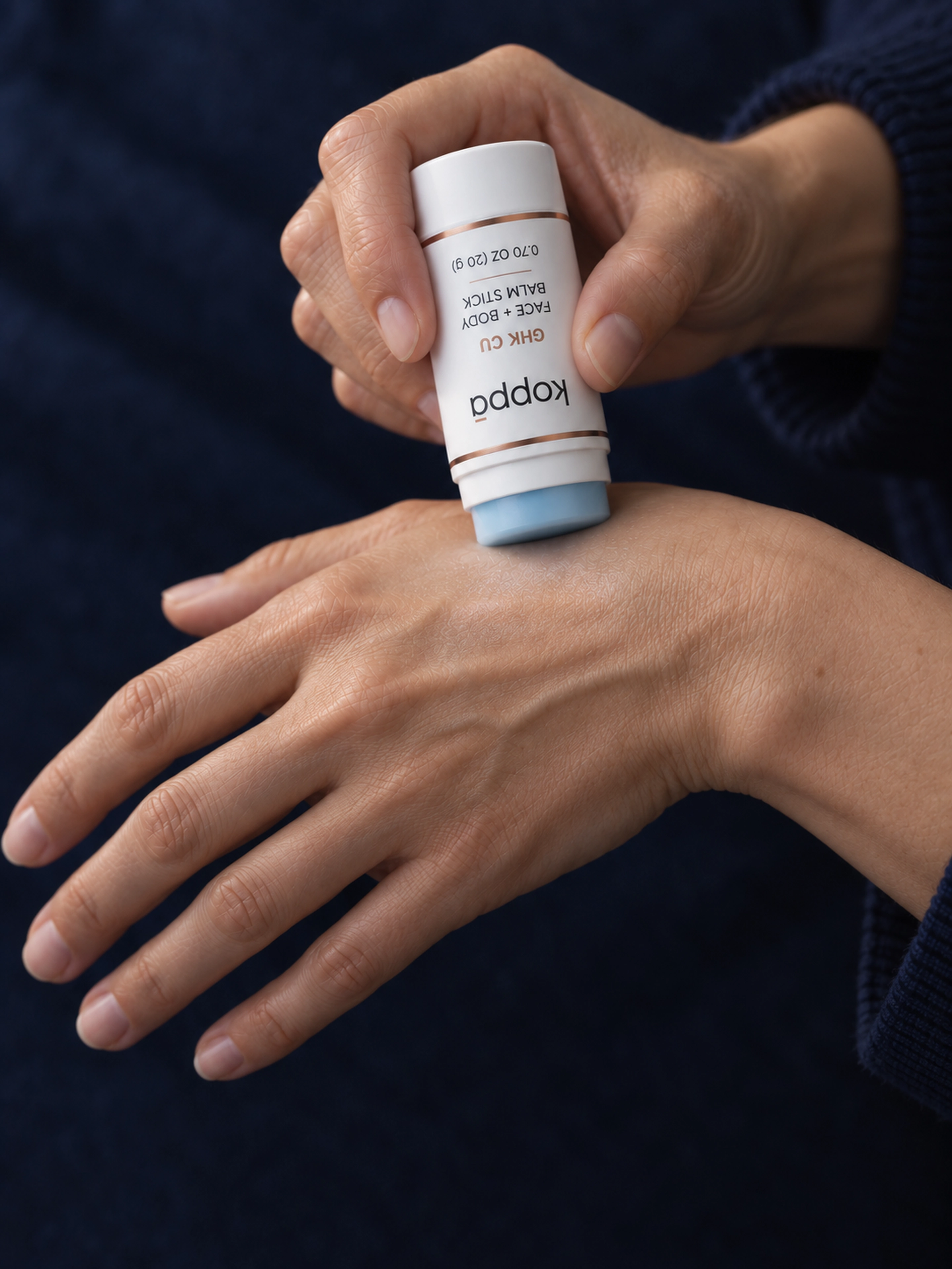 Koppā balm stick applied to the back of the hand