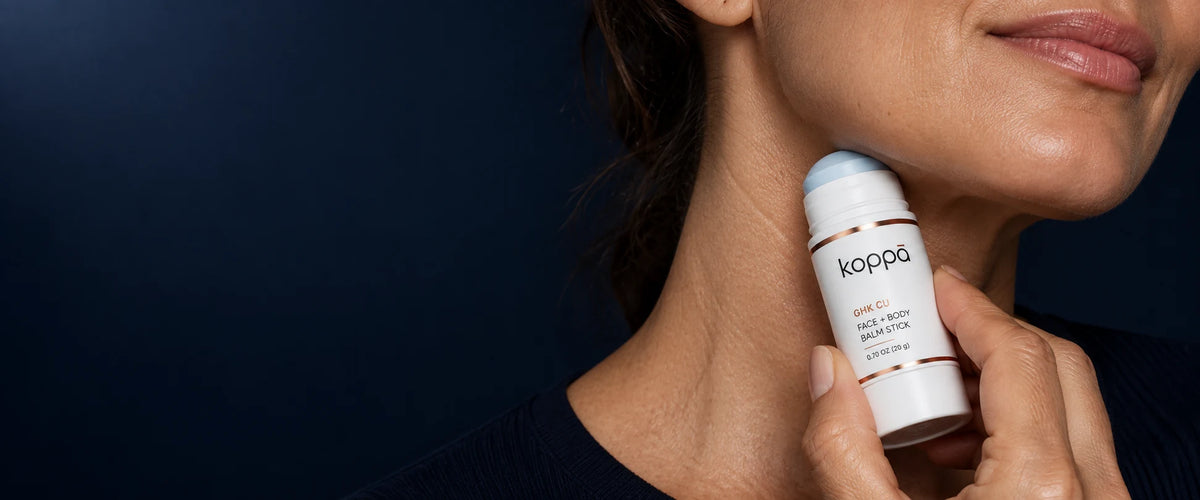 Koppā face and body balm stick pressed gently against the side of the neck